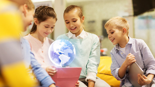 Teaching Children are watching a hologram in a classroom setting.