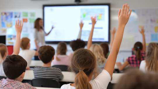 Classroom Several students raise their hands in class.